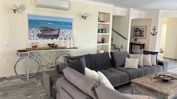 A living room with a gray sofa, a coffee table, and a bicycle.