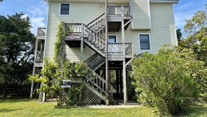 A two-story building with a wooden staircase and a balcony. - Wild Peony:  Incredible views from the ever popular rooftop deck! (Ocracoke)