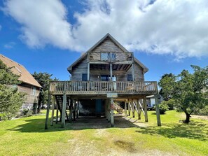 A two-story wooden house with a balcony, a sign indicating 'The Stock Room', and a number '206' on the post. - Jack Stocks' Place: Bright and cheerful, centrally located. (Ocracoke)