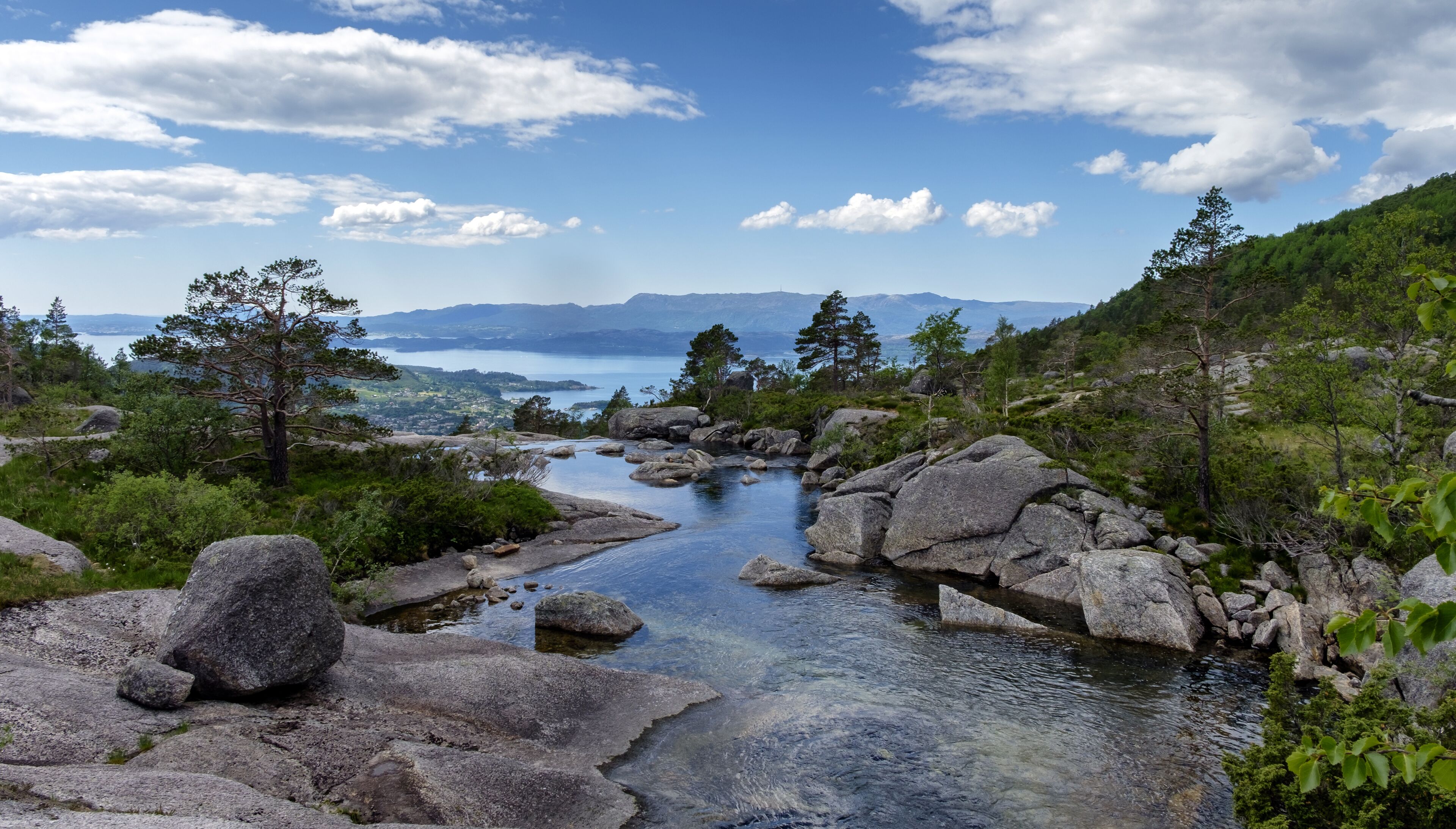 Un paisaje natural con un río, rocas y árboles.