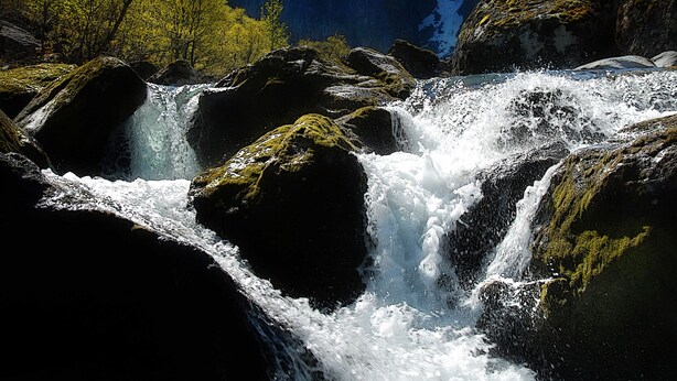 A waterfall cascading over rocks with a mountain in the background. - Husnes Sentrum Hotell (Kvinnherad)