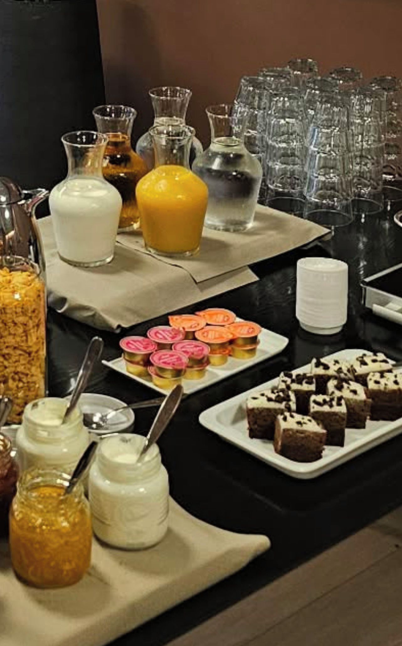 A buffet table with various food items and beverages.