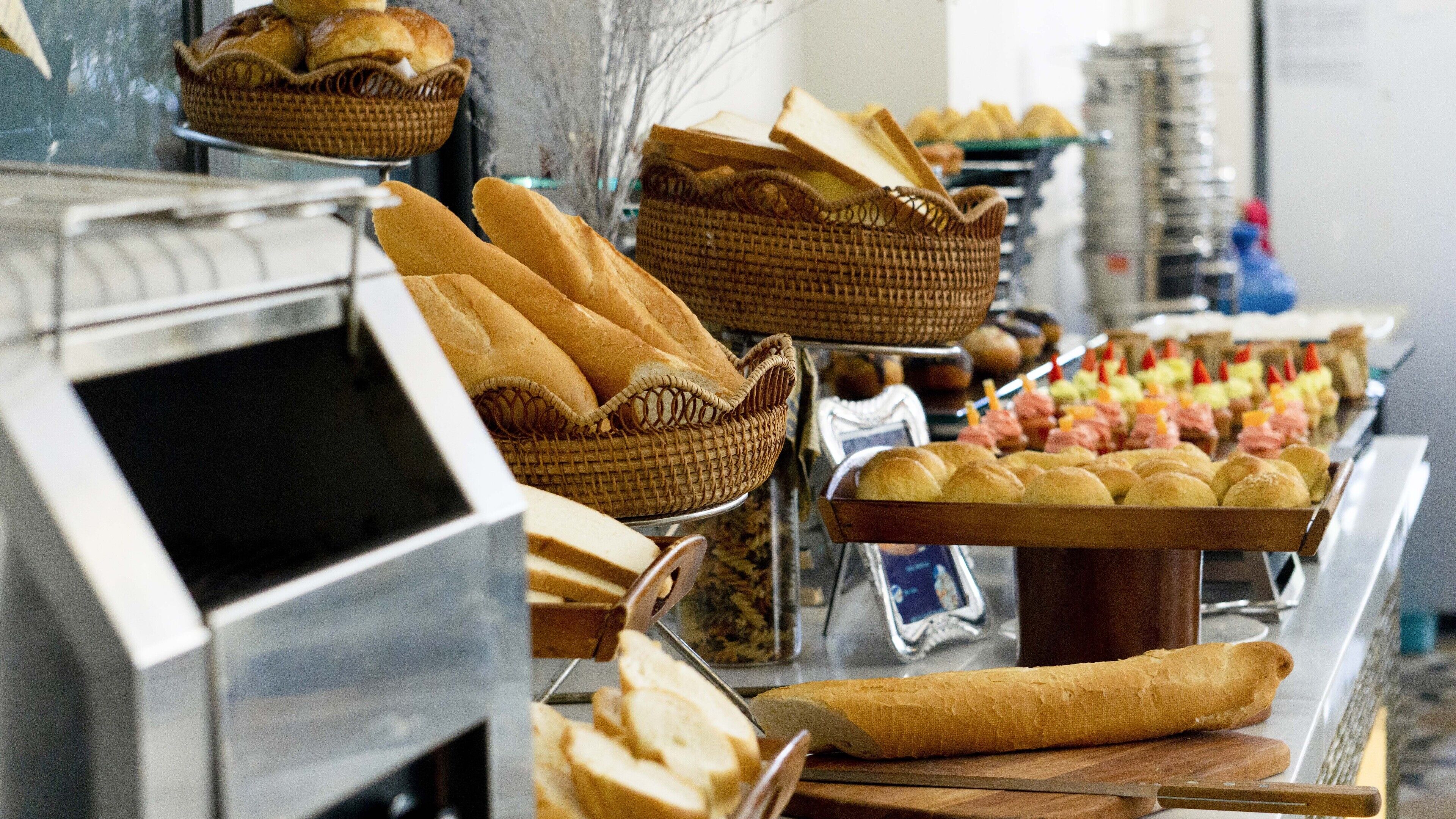 Un bufé con panes y pasteles variados.