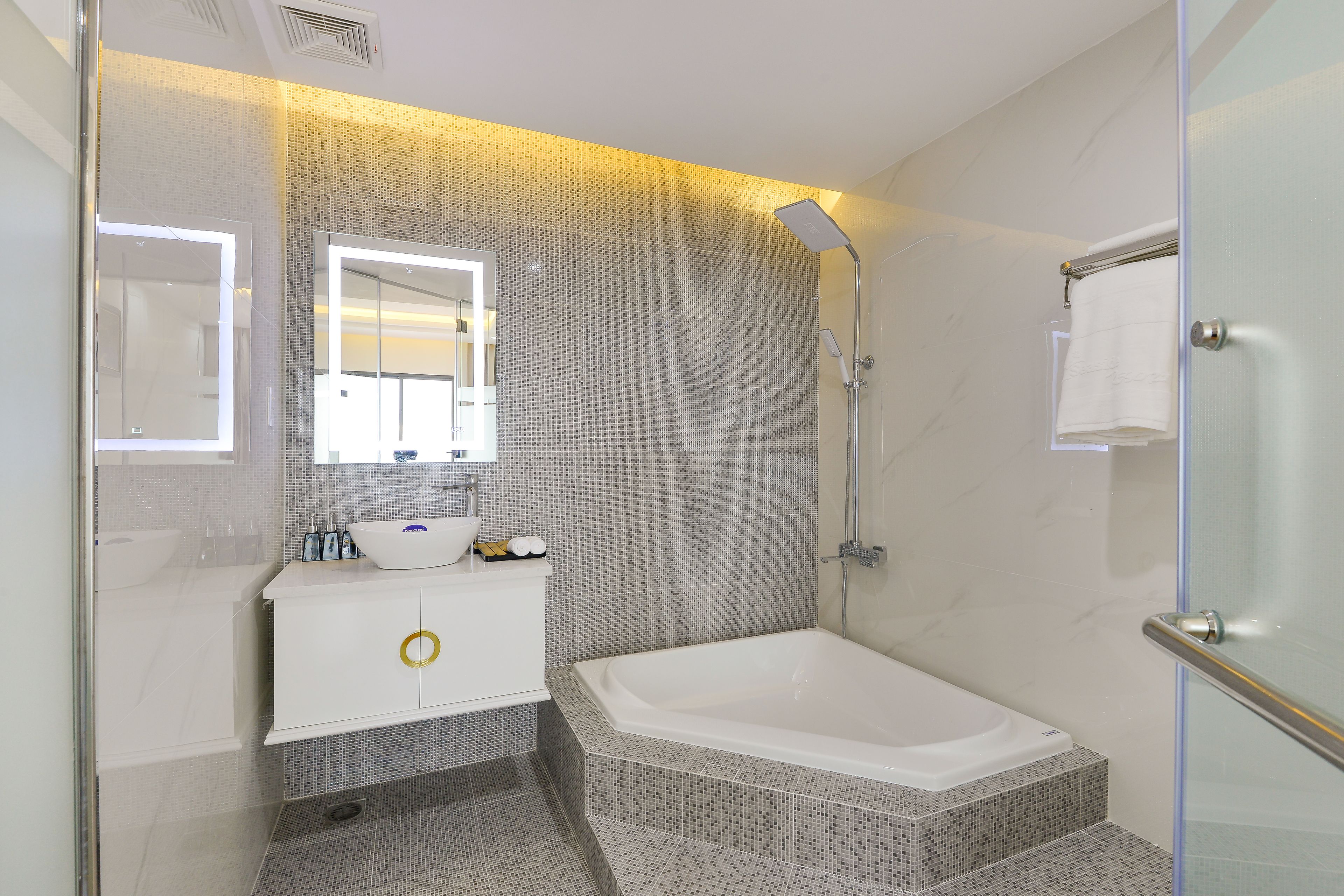 Une salle de bain moderne avec une douche à l’italienne en verre, une baignoire blanche et un meuble-lavabo avec un miroir.