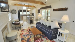 Un salon spacieux avec un canapé, une table basse et un tapis à motifs.