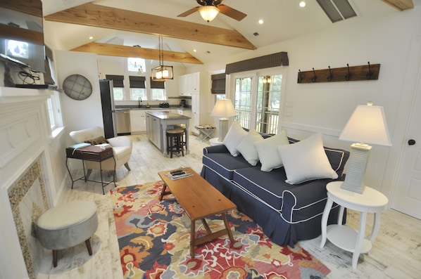 A spacious living room with a sofa, coffee table, and a patterned rug.