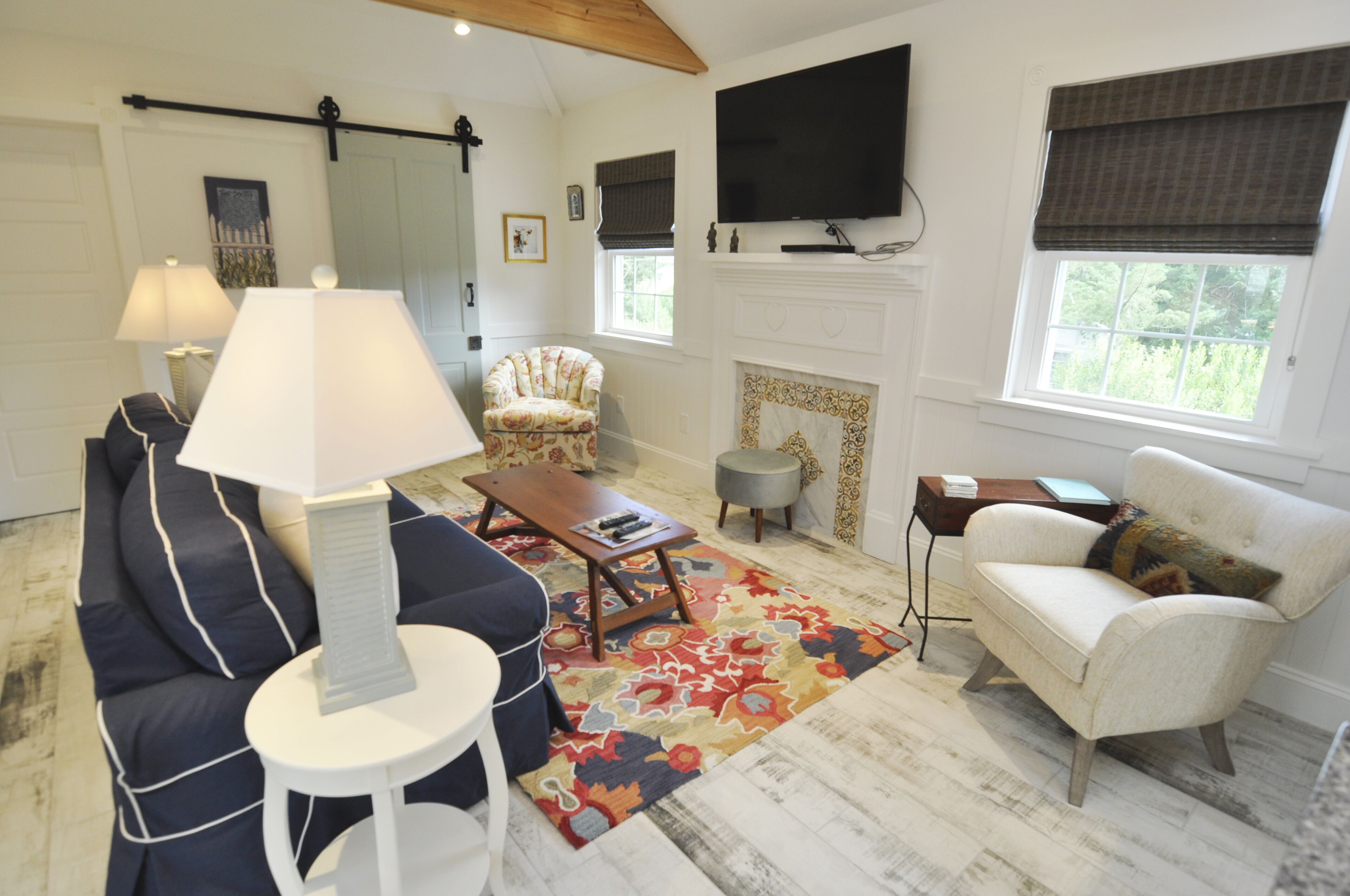 A living room with a sofa, armchair, coffee table, and a fireplace.