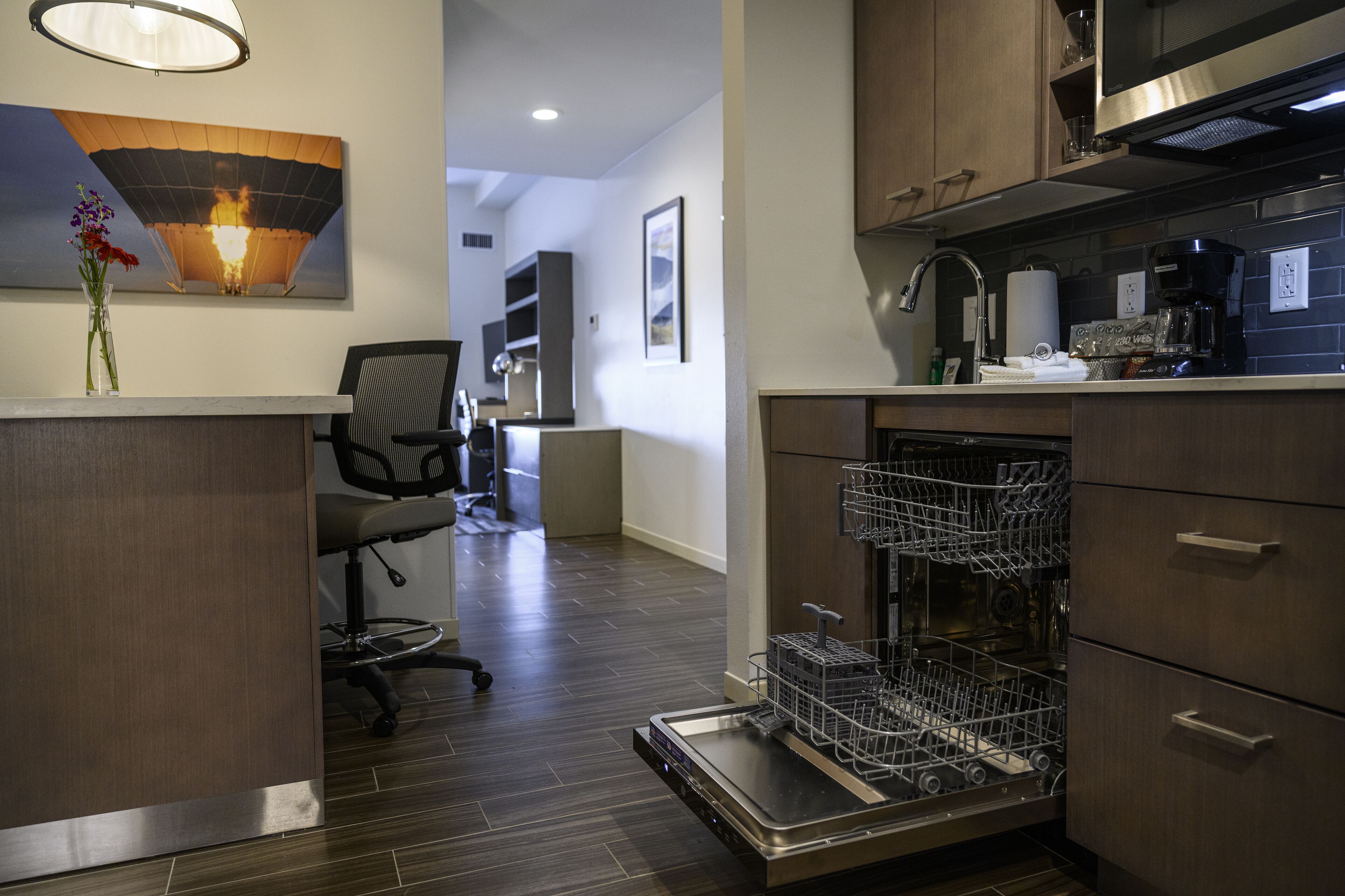 A modern kitchen with a dishwasher, a coffee maker, and a sink.