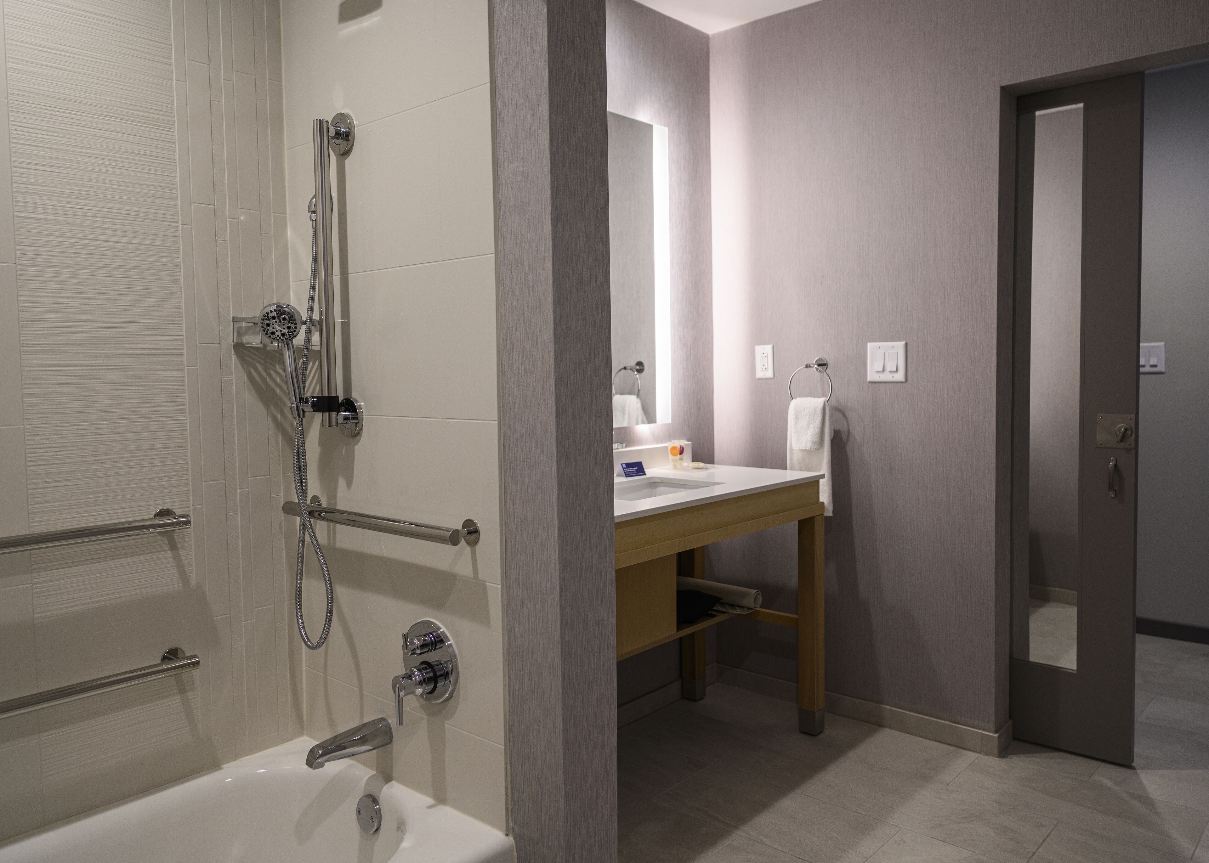 Une salle de bain moderne équipée d’une baignoire, d’une douche et d’un meuble-lavabo.