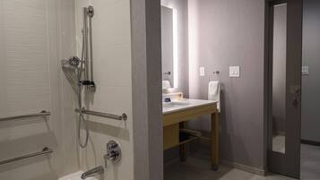 Une salle de bain moderne équipée d’une baignoire, d’une douche et d’un meuble-lavabo.