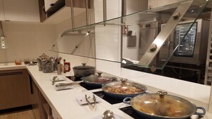 A modern kitchen with stainless steel appliances, a glass backsplash, and a wooden floor. - Hyatt Place Indianapolis / Fishers (Fishers)
