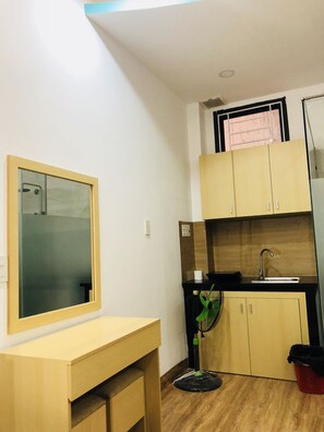 Cozinha compacta com bancada de madeira, pia e armários.