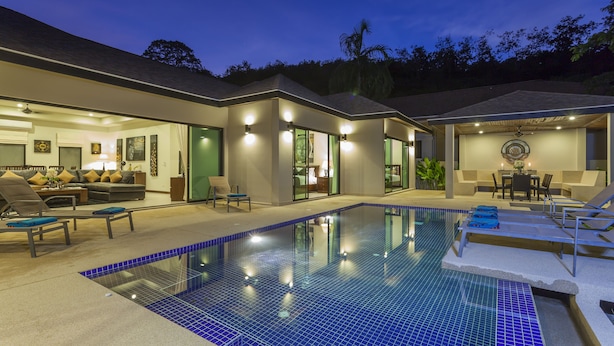 Une maison moderne dotée d’une piscine, d’un espace extérieur aménagé et d’un intérieur bien éclairé.