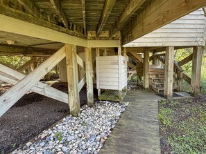 A wooden structure with a gravel pathway and a wooden staircase leading to an upper level.