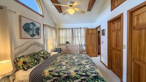 A bedroom with a bed, a ceiling fan, a window, and a door. - Xenia House:  Enjoy decks and screened porch overlooking the marsh. (Ocracoke)