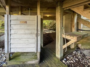 Une structure en bois dotée d’une porte en bois, d’un escalier en bois et d’une plateforme en bois.