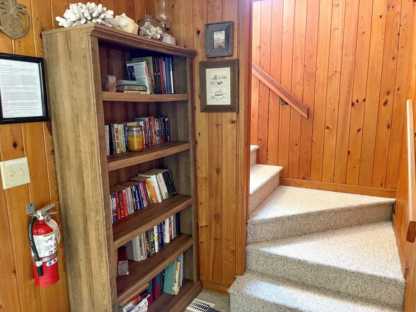 Una scala in legno con una libreria piena di libri e oggetti decorativi.