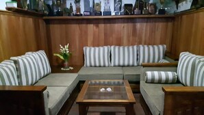 Un salon chaleureux avec un parquet, une table basse en verre et des canapés à rayures.