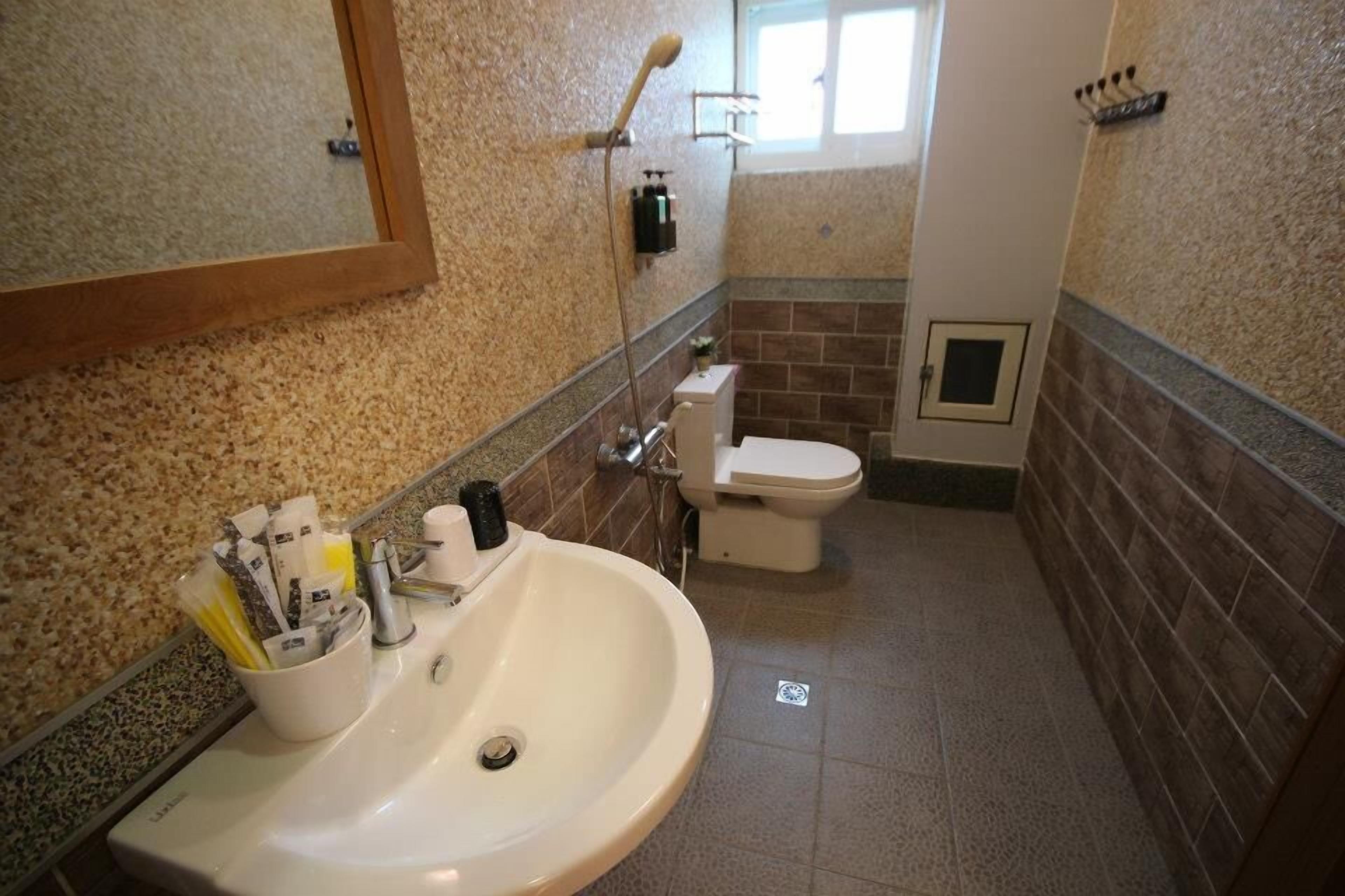 Un baño con lavamanos, inodoro y ducha.
