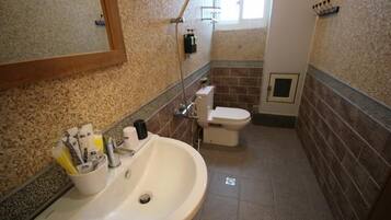 A bathroom with a sink, toilet, and shower.