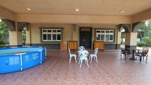 Un área de patio al aire libre con piscina, mobiliario y una puerta con señalización.