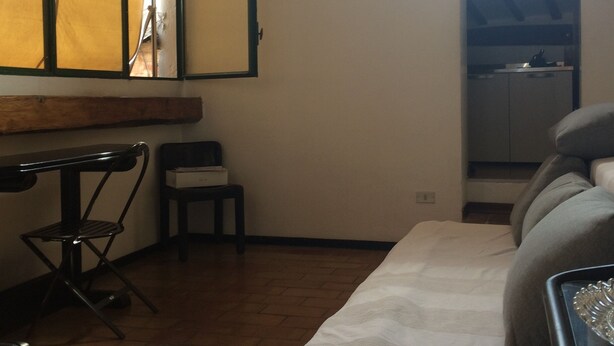 Un dormitorio con cama, escritorio, silla y ventana.