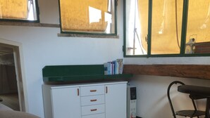 Una habitación con una cama, un escritorio, una silla, un armario y una ventana.