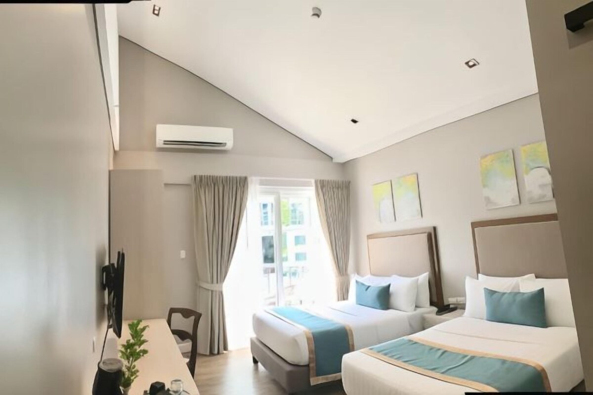 Une chambre d’hôtel avec deux lits, une table à manger et un téléviseur.
