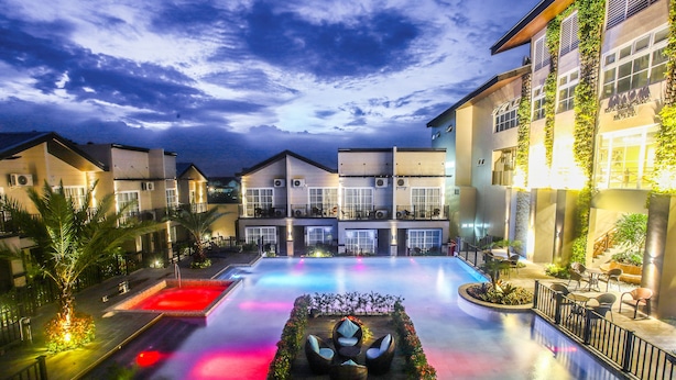 A hotel courtyard with a swimming pool, outdoor seating, and a well-lit walkway. - Royale Parc Hotel Tagaytay (Tagaytay)