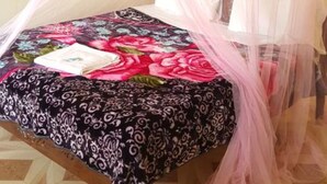 A bed with a floral bedspread, a canopy, and a window with curtains. - Sultan Hamud Pyramids Resort (Sultan Hamud)