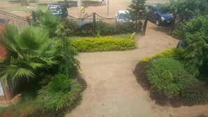 A paved pathway leading to a gated entrance with lush greenery and a palm tree on the left. - Sultan Hamud Pyramids Resort (Sultan Hamud)