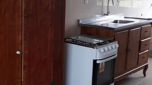 A kitchen with a gas stove, a sink, and wooden cabinets. - 03 Apartments for Vacation - Morada Madruga - Sea Front, Superior (Praia do Sonho (Ens Brito))
