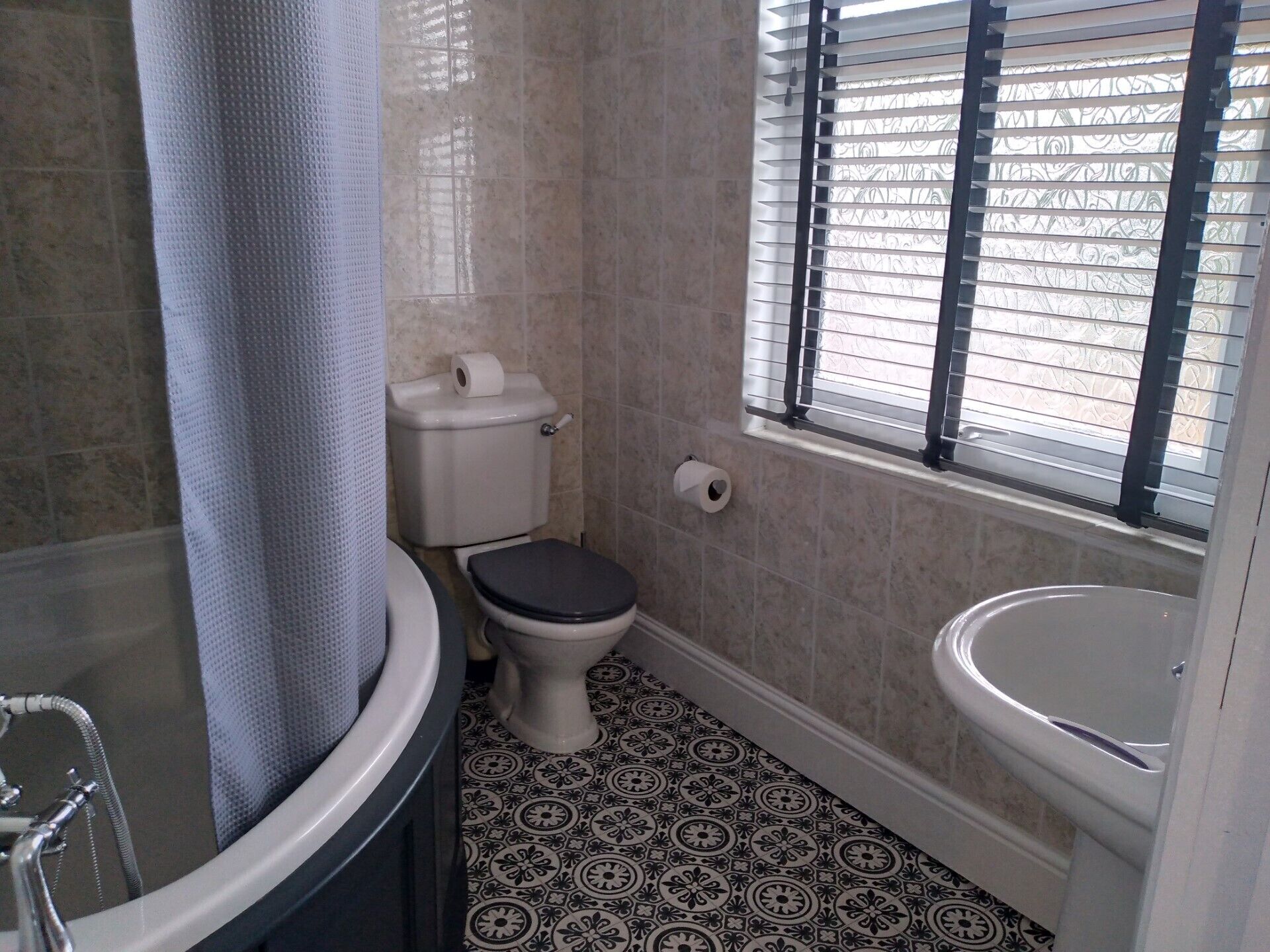 A bathroom with a toilet, bidet, and bathtub.