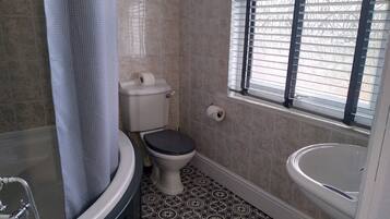 A bathroom with a toilet, bidet, and bathtub.
