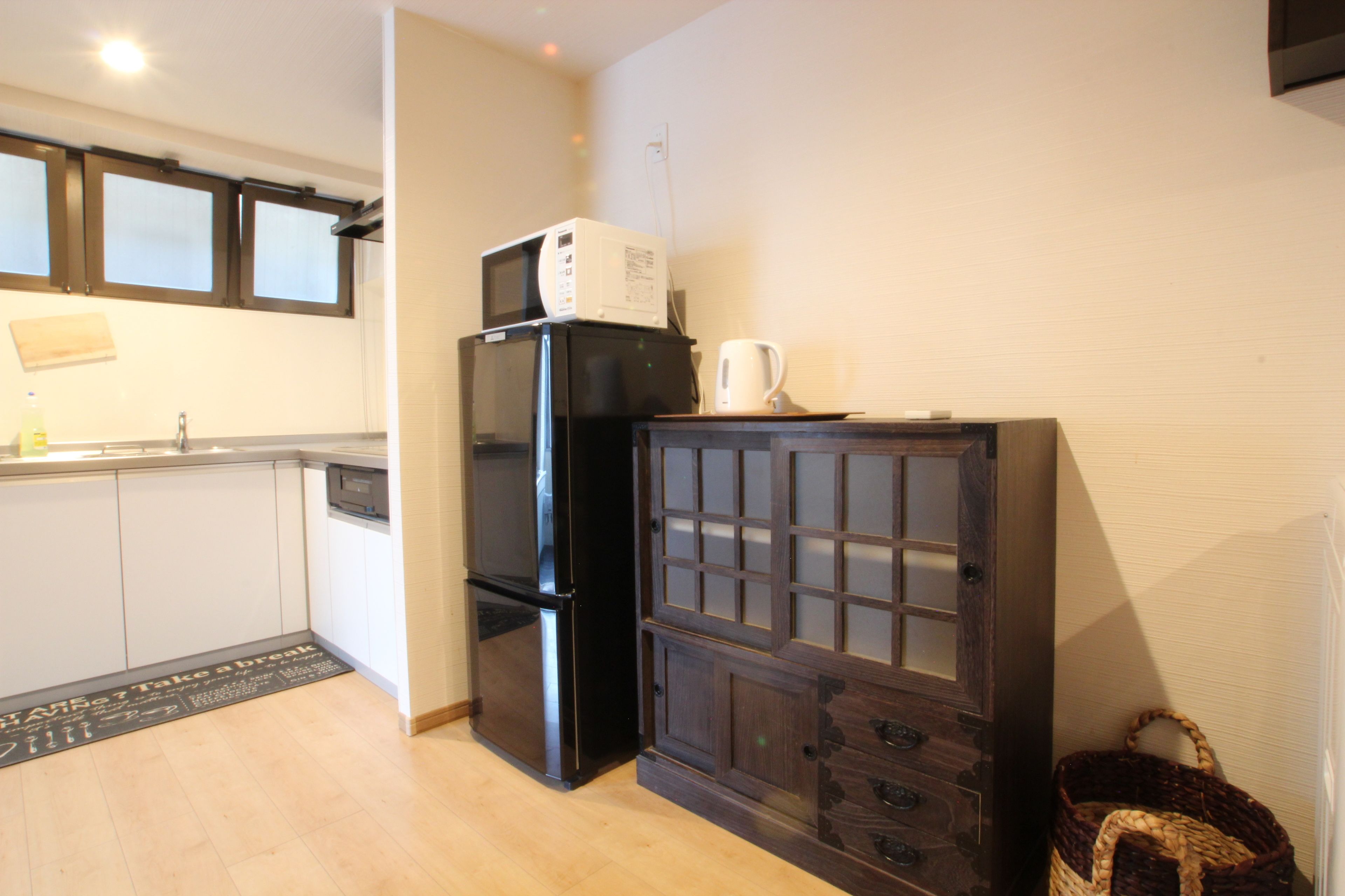 A compact kitchen with a refrigerator, microwave, and a cabinet with drawers.