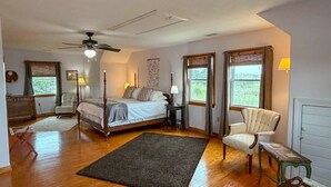 Un dormitorio con cama con dosel, ventilador de techo, escritorio y silla.