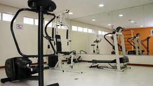 A gym with cardio machines, weightlifting equipment, and mirrors on the walls. - Residence Plaza Flat (Ribeirão Preto)