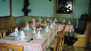 A dining area with tables set for a meal, chairs, and a bench. - Gasthaus & Pension Koch (Cursdorf)