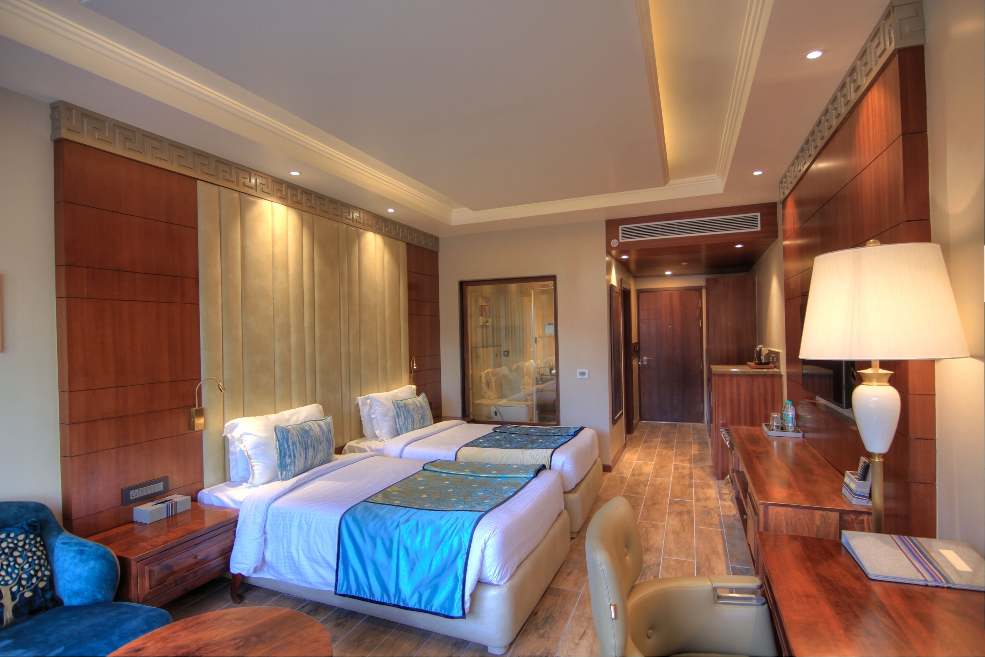 Une chambre d’hôtel avec deux lits, un bureau, une chaise, un canapé et une salle de bain.