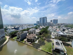 A cityscape with modern buildings, a river, and a clear sky. - Gold Coast PIK Sea View Apartments by LongeSuites (Jakarta)