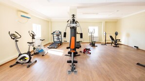 A gym with various exercise equipment including treadmills, an elliptical, and weight machines. - Dostyk Hotel Bautino (Fort Shevchenko)