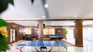 A spacious indoor area with a ping pong table, a pool table, and comfortable seating. - Dostyk Hotel Bautino (Fort Shevchenko)