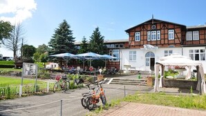 A building with a traditional architectural style, featuring a prominent entrance and a covered outdoor seating area.