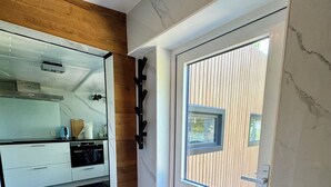 Una cocina moderna con horno empotrado, cafetera y encimera de madera.