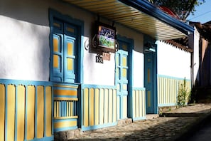 A building with blue and yellow doors, a clock, and a cobblestone street. - Pleasant house in the magic town of Salento (Salento)