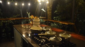 Una cocina con estufa, ollas y una mesa de comedor.