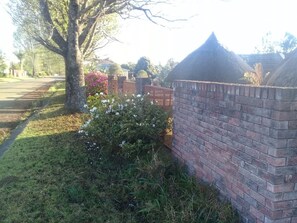 Eine Ziegelwand mit einem kleinen Garten und einem Baum.