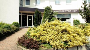Entrada de un hotel con un cartel que dice 'KNIESTEDTER HOF - HOTEL'.