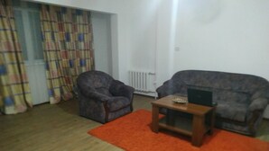 A living room with two armchairs, a coffee table, and a laptop. - Welcome Home 20 (Tashkent)