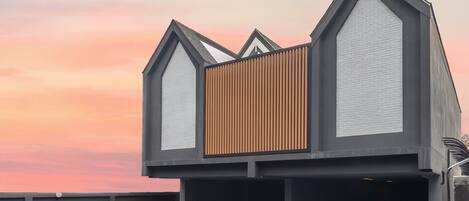 Un edificio moderno con un diseño arquitectónico único que incorpora elementos triangulares y paneles de madera.